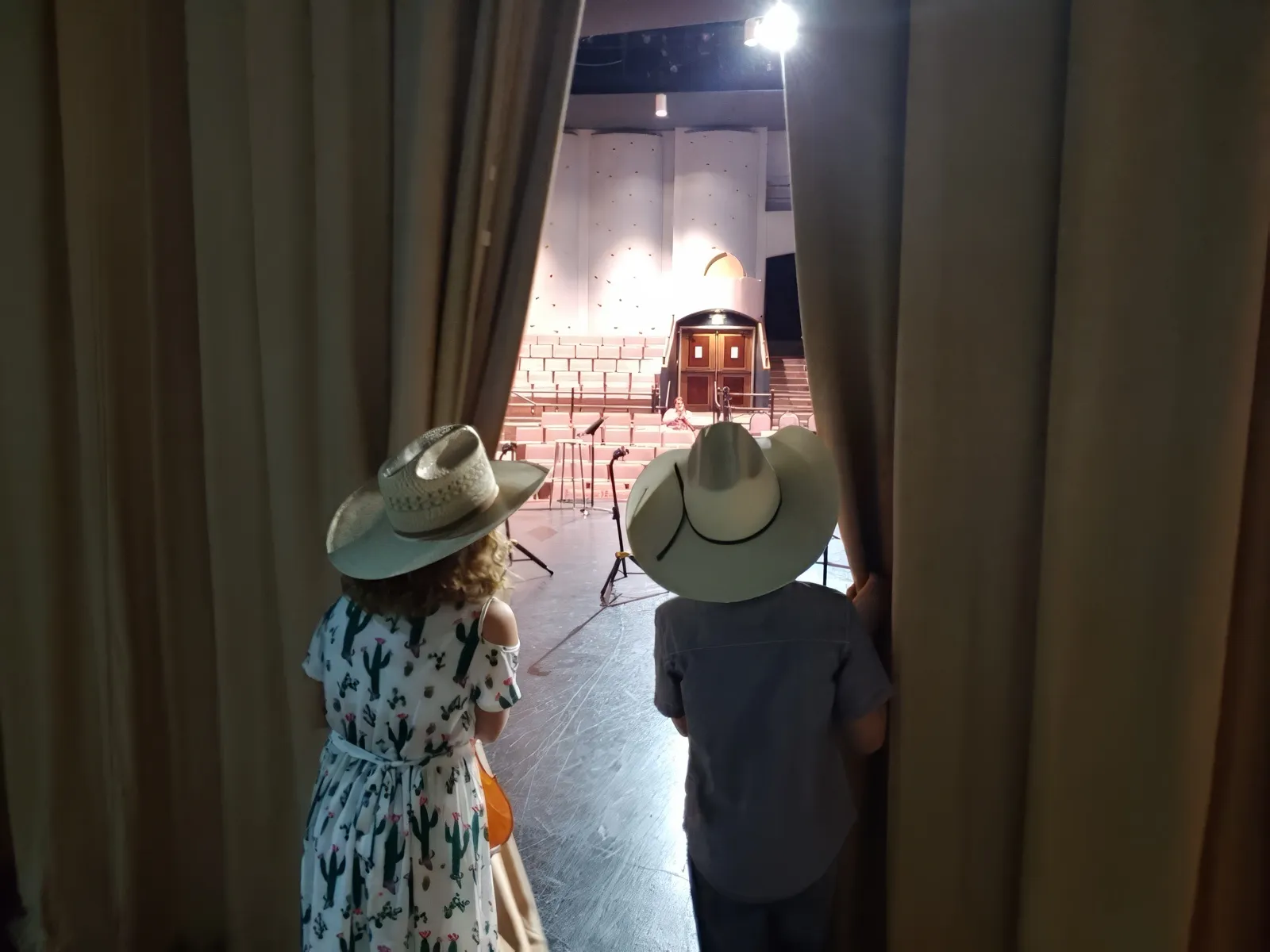 Young campers peek out from behind the stage curtain in the early years