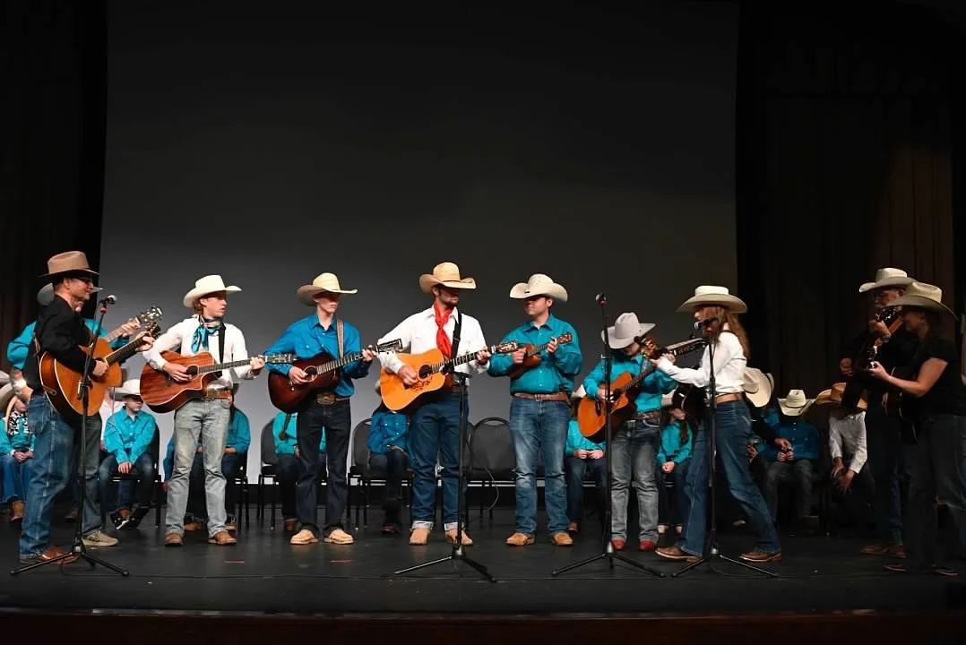 Campers perform with guitars on stage at the finale concert